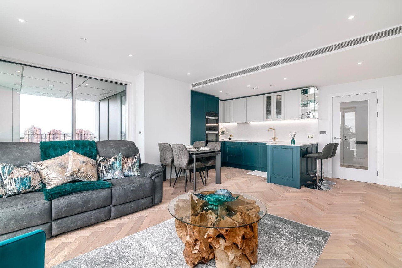 London apartment refurbished by MALCON: open-plan living room with navy Shaker-style kitchen and herringbone floor