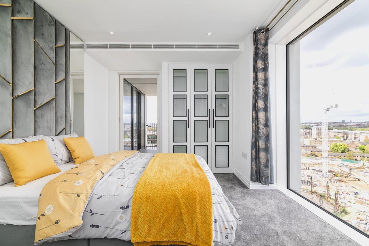Bedroom with fitted wardrobes with glazed doors, fitted by MALCON in a London apartment