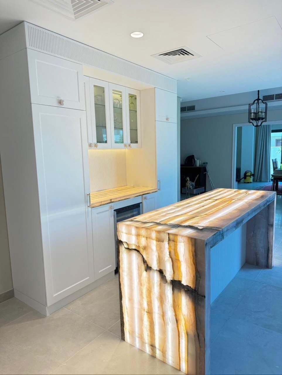 Completed MALCON white fitted kitchen featuring an illuminated translucent stone island and integrated cabinetry