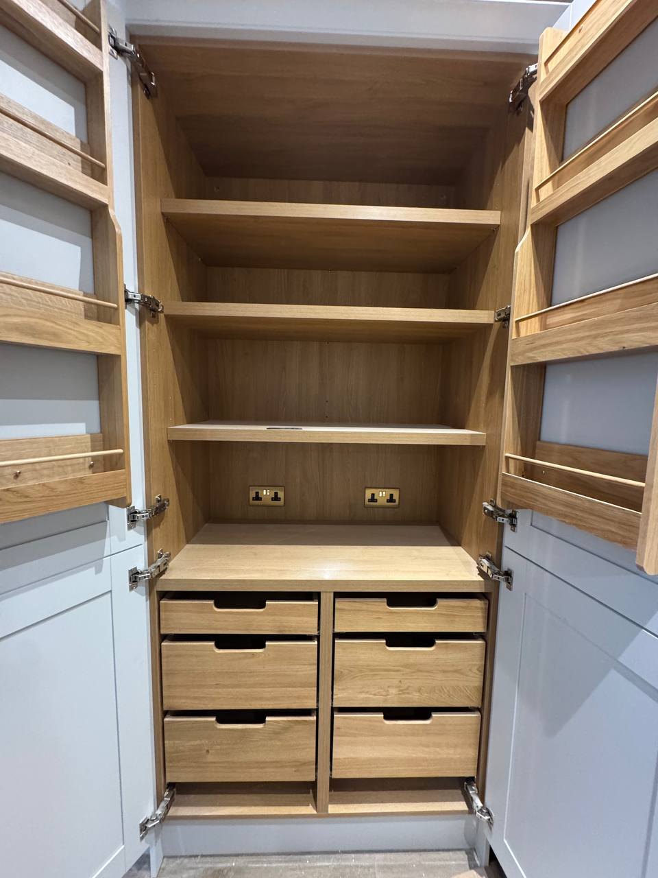 Full-height kitchen larder with oak shelving and drawers by MALCON