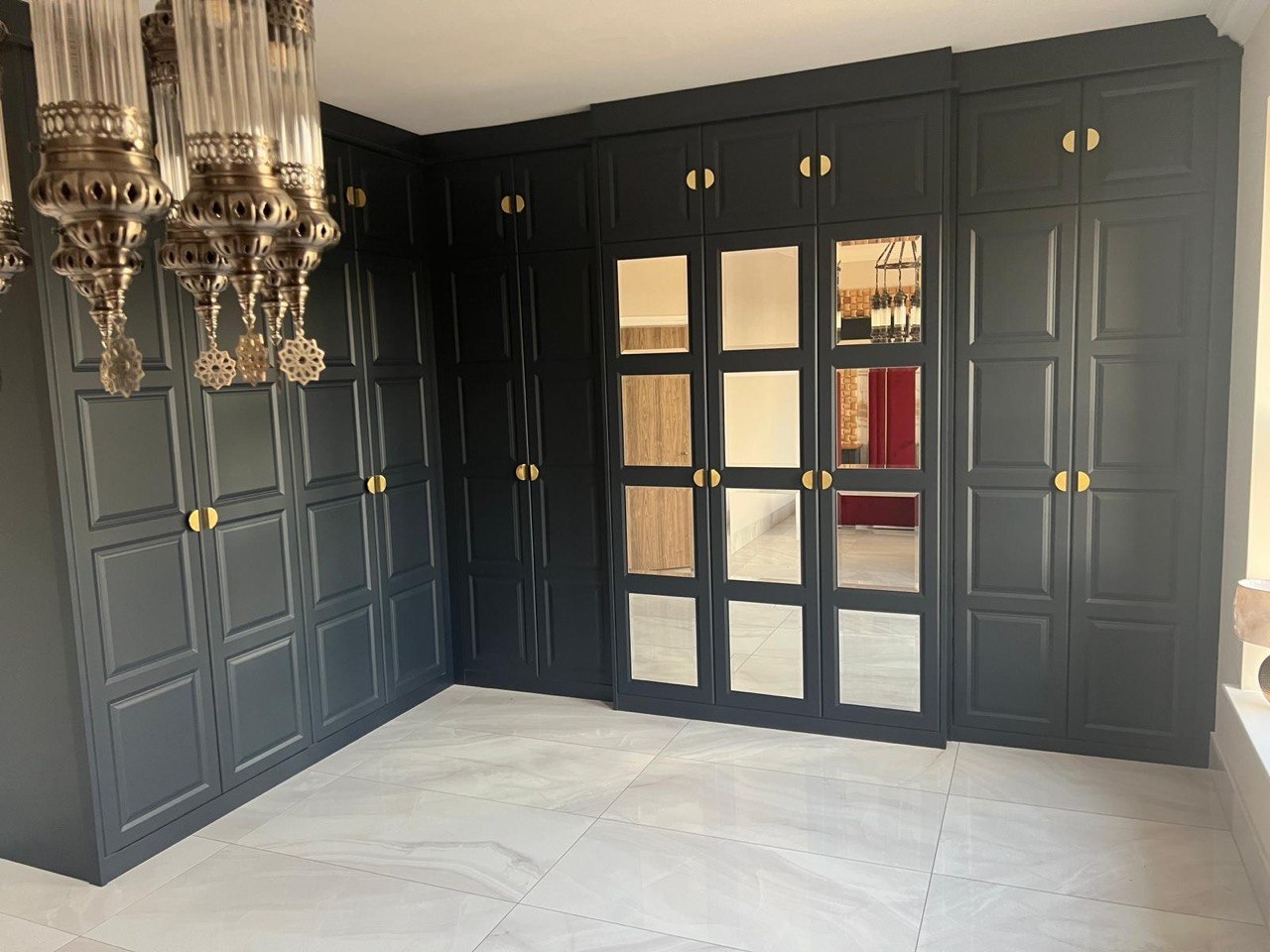Full-height bespoke fitted wardrobe with brass handles completed by MALCON